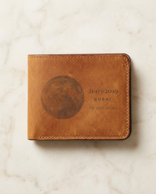 Moon and date laser engraved on a tan leather wallet