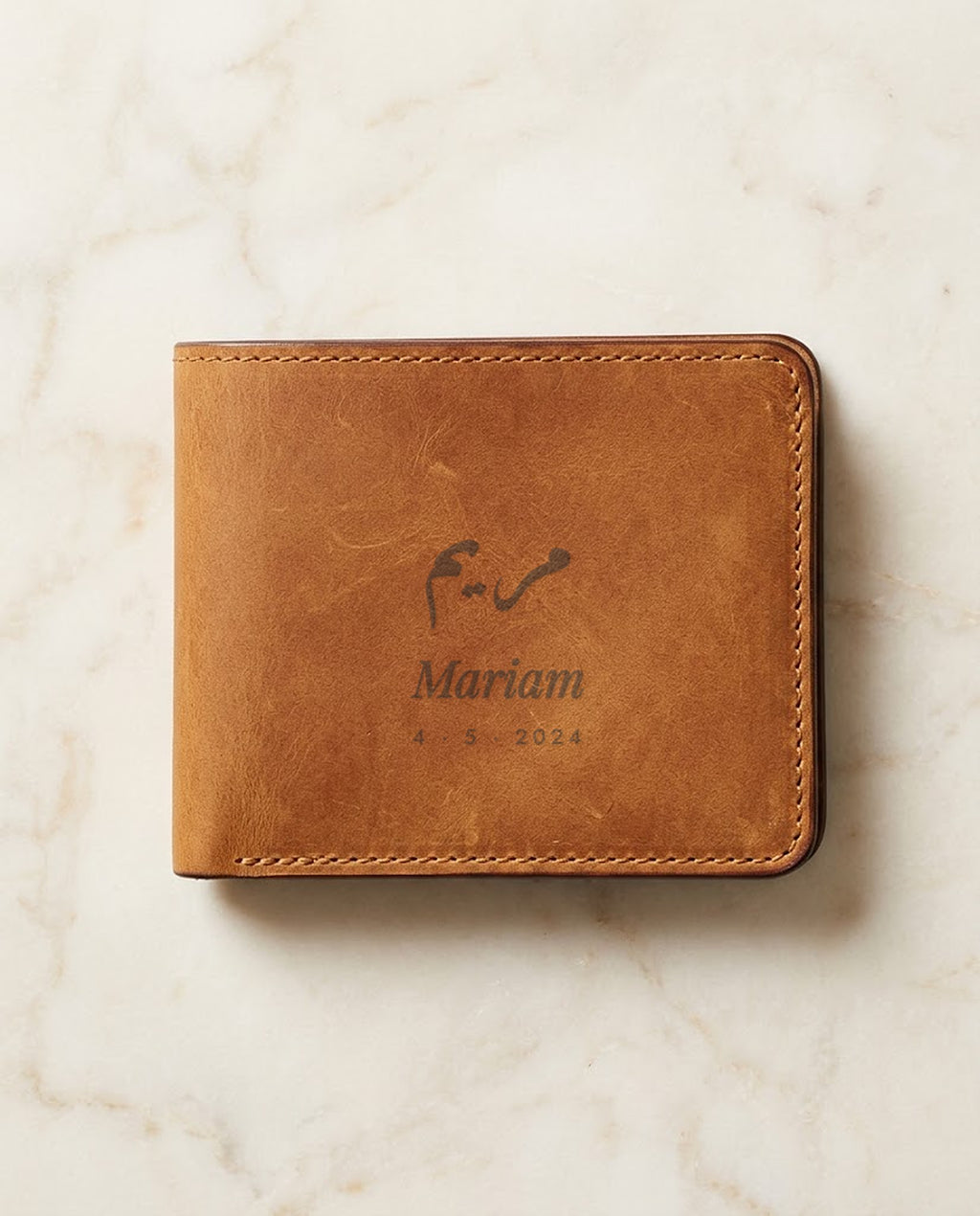 Arabic and English name laser engraved on a tan leather wallet
