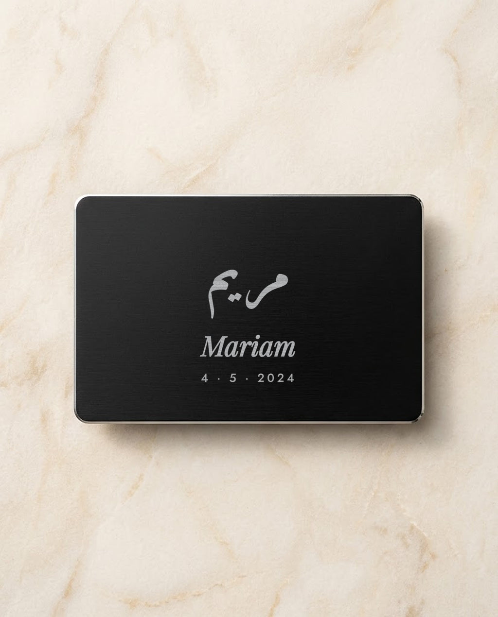 Arabic and English name engraved on a black metal card