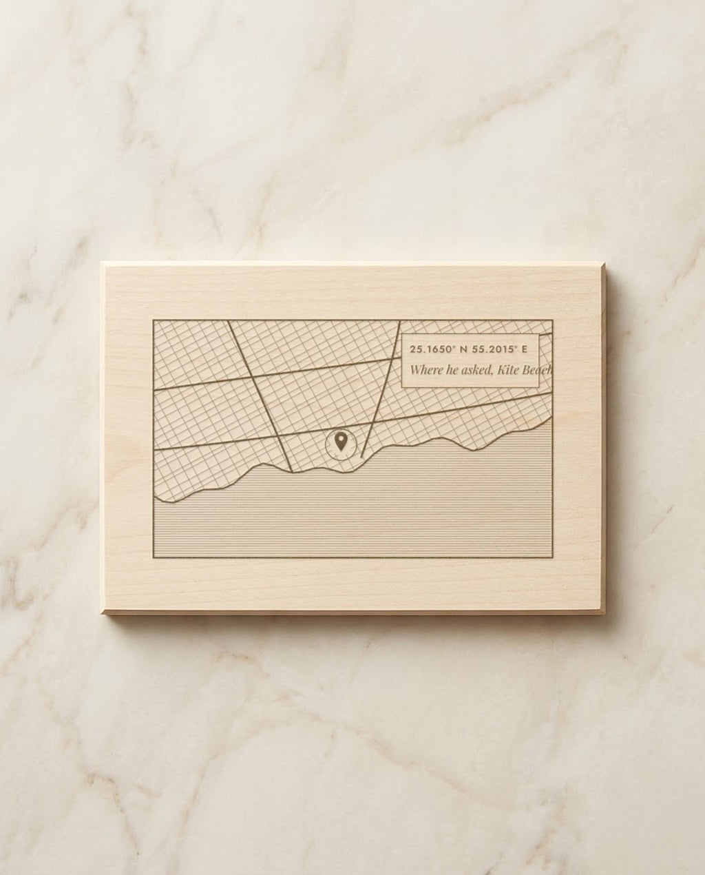 Street map of Kite Beach, Dubai with a pin and coordinates engraved on a basswood plaque