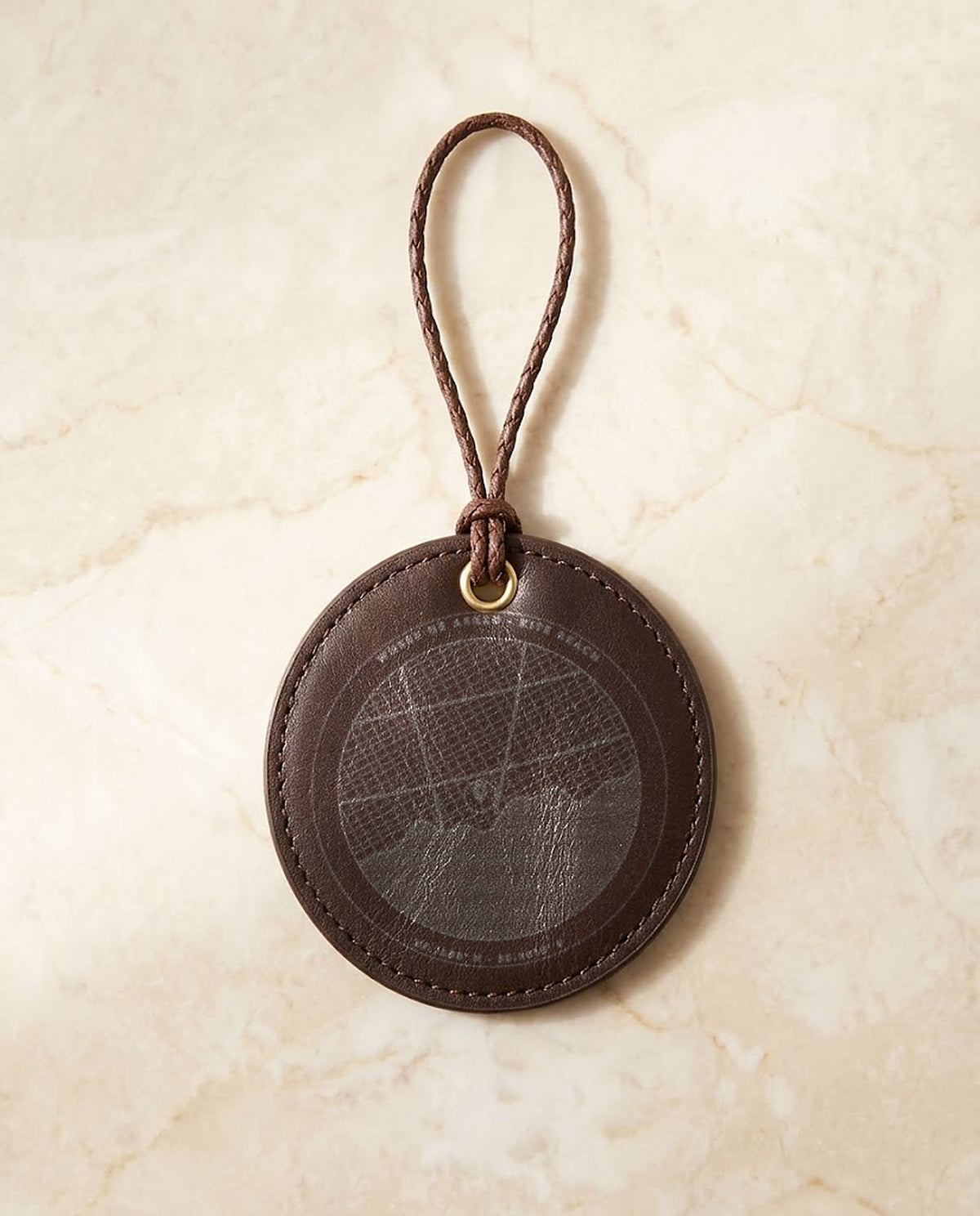 Street map with pin and coordinates engraved on a leather hanging medal