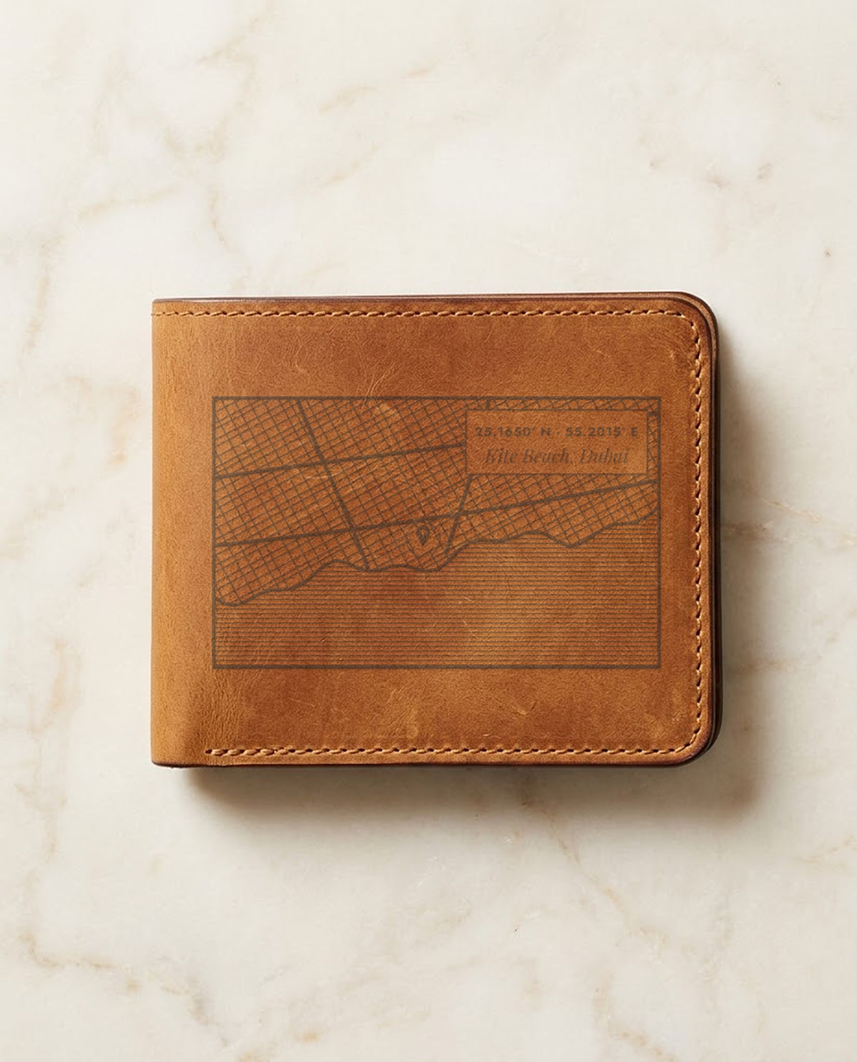 Street map with pin and coordinates laser engraved on a tan leather wallet