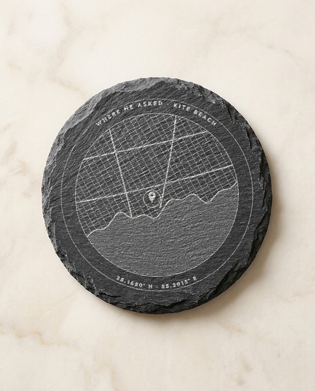 Street map with pin and coordinates engraved on a round slate coaster